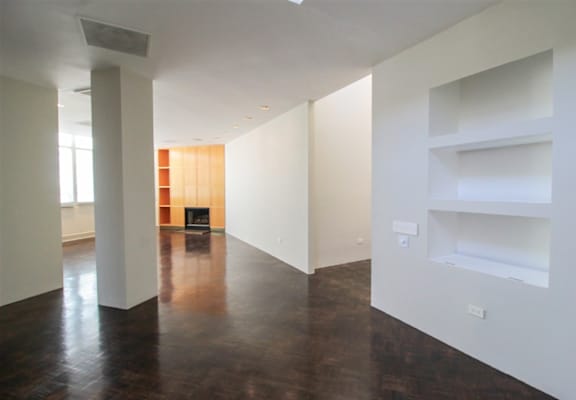 an empty room with white walls and wood floors