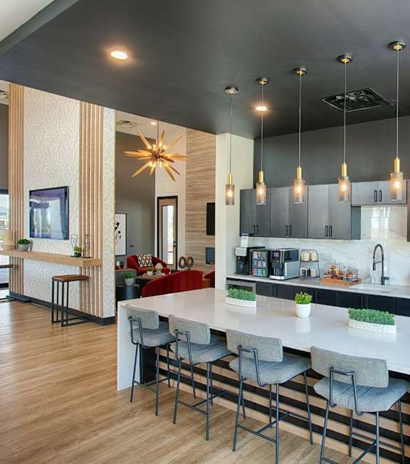 A modern kitchen with a long island and bar stools.