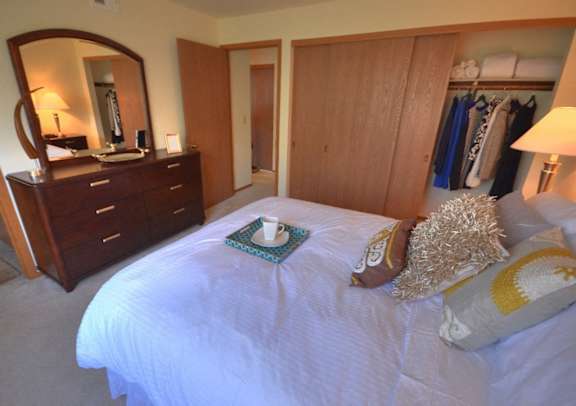 a bedroom with a bed and a dresser and a mirror