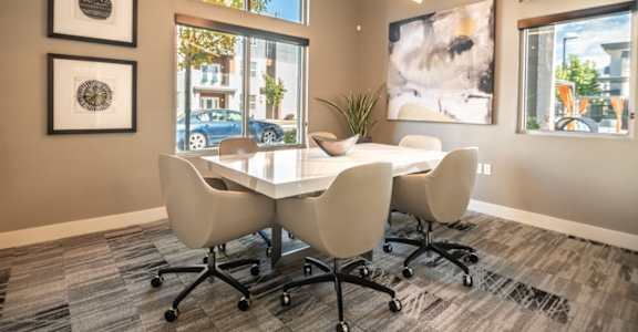 A conference room with a table and chairs and pictures on the wall.