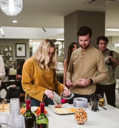 a group of people in a kitchen preparing food and drinking wine  at The Grand, Kansas City, Missouri