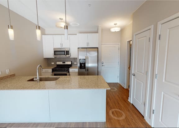 A kitchen with a sink, stove, and refrigerator.
