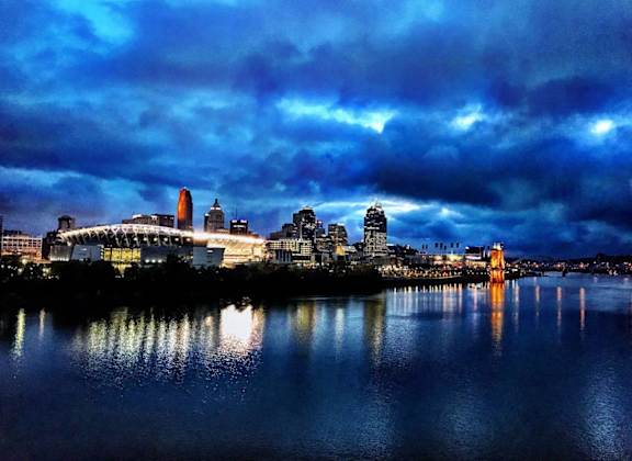 A city skyline is reflected in the water at night.at Sky Central, Cincinnati, OH