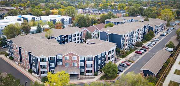an aerial view of an apartment complex with cars parked in a parking lot