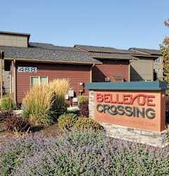 A sign in front of a building that says Believe Crossing.