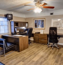 a room with a desk and chairs and a tv  at Hibiscus Place Apartments in Orlando, FL, 32808