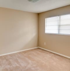 A room with a window and carpeted floor  at Hibiscus Place Apartments in Orlando, FL, 32808