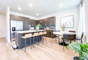 A kitchen with a bar area and a dining table.
