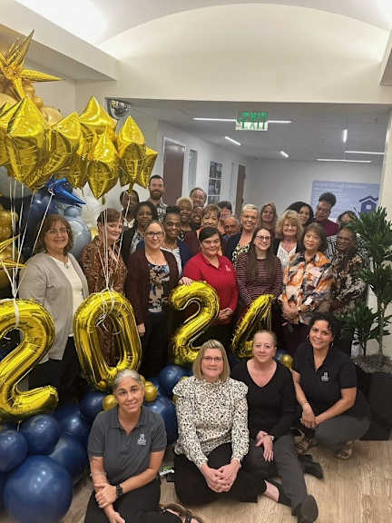 a group of people posing for a photo with balloons and 2020