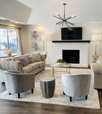 Clubhouse interior with comfortable couches, fireplace, and large windows at Park at Meadow Ridge Apartments in Montgomery, AL