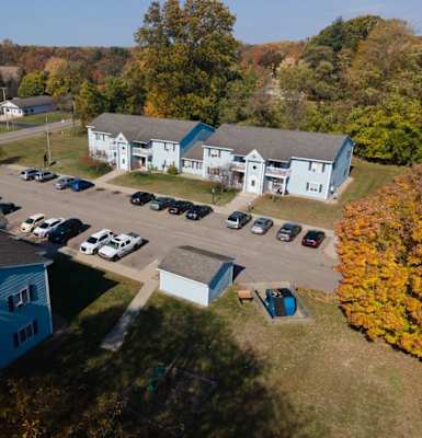 arial view of a blue building with a parking lot and other buildings in the background