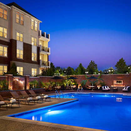 A swimming pool surrounded by lounge chairs and umbrellas at a hotel.