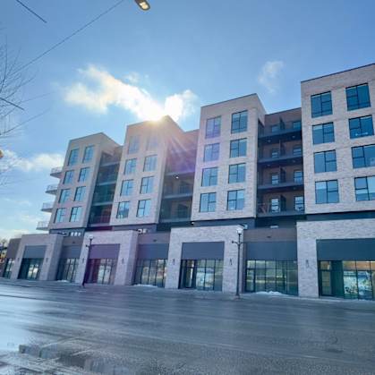 A modern multi-story building with a mix of residential and commercial spaces.