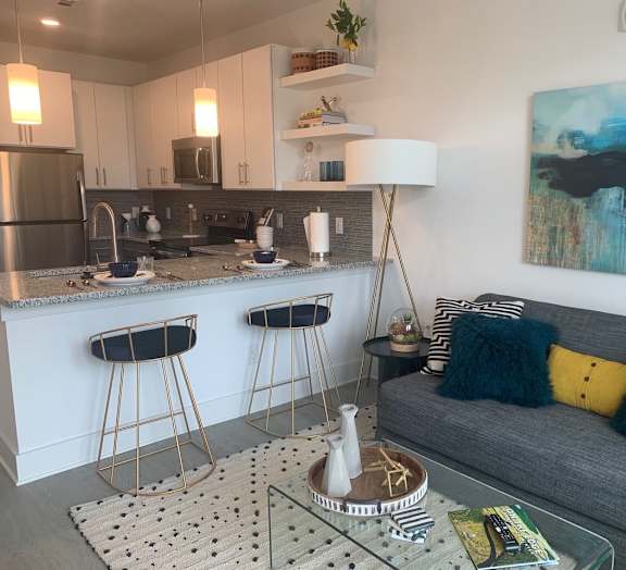 a living room with a kitchen in the background