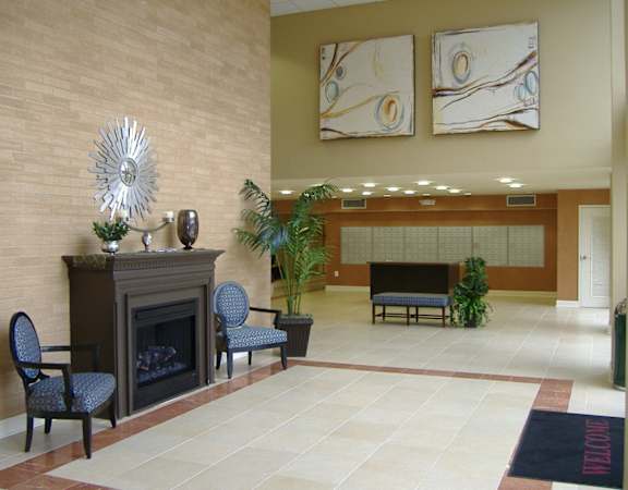 A living room with a fireplace and two chairs.