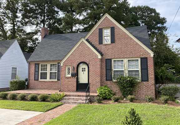 a brick house with a white door and black shutters