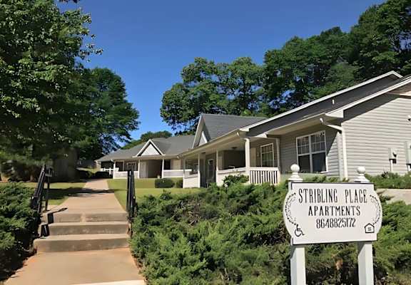 A sign for Stribling Place Apartments stands in front of a building.