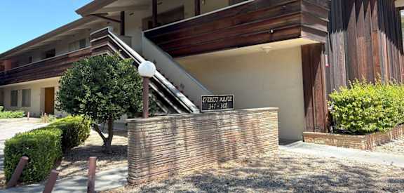 A modern house with a wooden exterior and a sign that reads "1707 ALLEN".