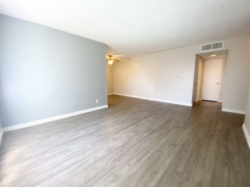 the living room and dining room of an empty apartment