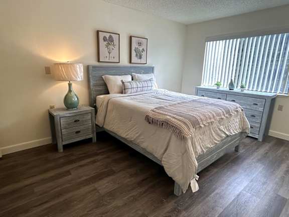A bedroom with a bed, nightstand, and lamp.