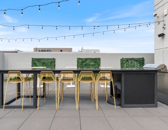 a bar table on the roof of a building with bar stools
