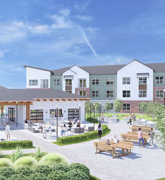 A modern building with a spacious courtyard and people walking around.