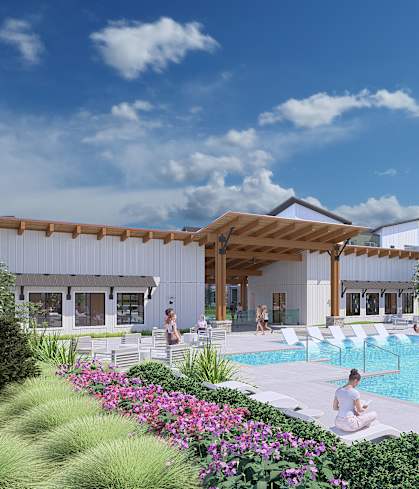 A pool area with people relaxing and a building in the background.