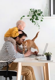 a man with a baby and a cat looking at a laptop computer at Sterling Creek, Richmond Hill Georgia