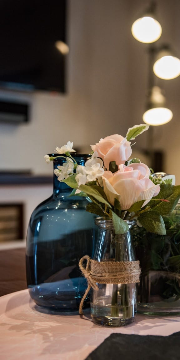 a blue vase with flowers on a table