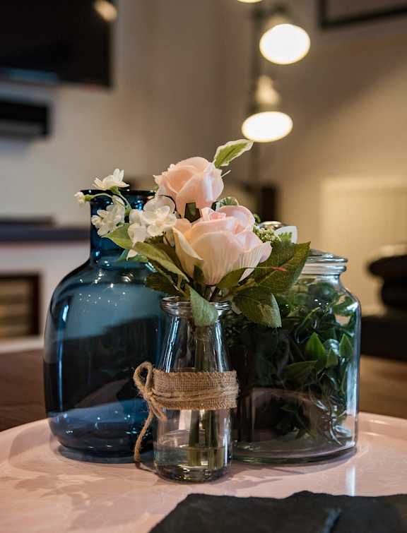 Two vases with flowers in them are on a table.