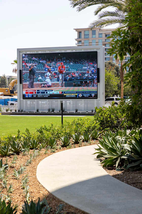 A large outdoor television screen is displaying a baseball game. at Elements Apartments*, Irvine, CA, 92612