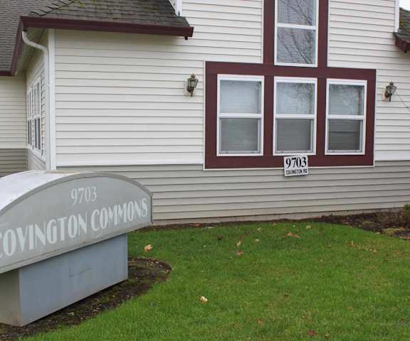 A sign for Covington Commons sits in front of a house.