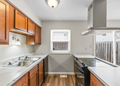 A kitchen with wooden cabinets and a window.