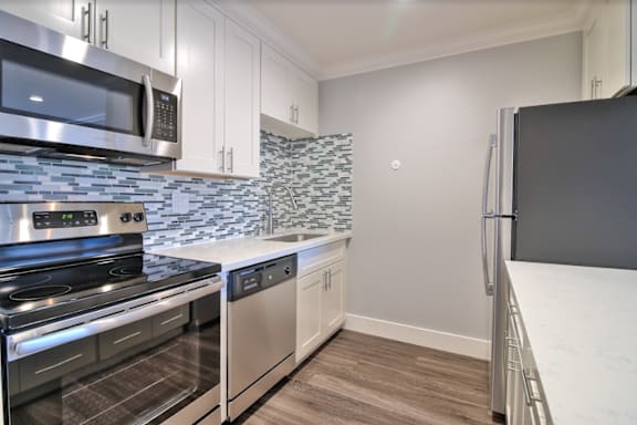 A kitchen with white cabinets and stainless steel appliances.