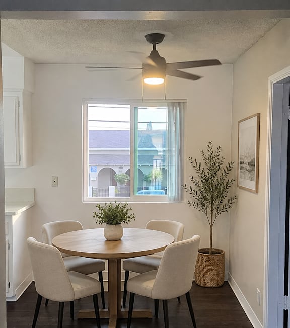 A well-lit, modern kitchen and living room with a dining area.