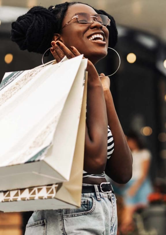 a woman holding shopping bags in a store