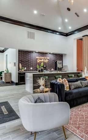 A modern living room with a black couch and a wooden coffee table.