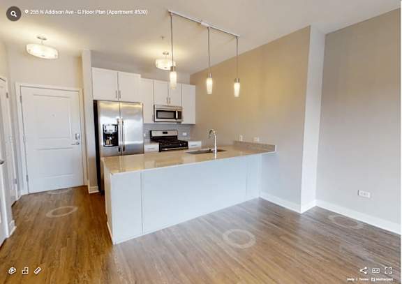 A kitchen with a refrigerator, microwave, and oven.