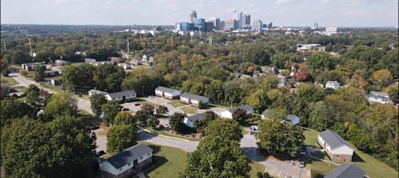 an aerial view of a neighborhood with a city skyline in the background at Trails Corner Apartments, North Carolina, 27610