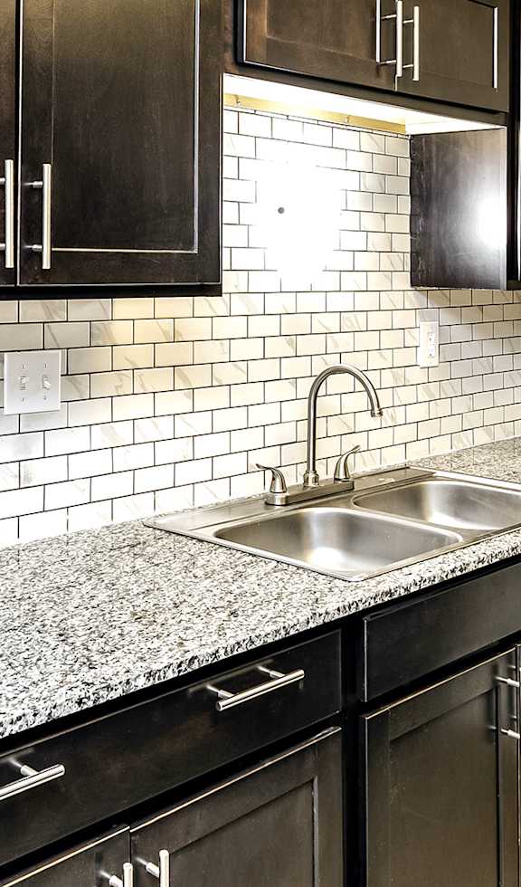 a kitchen with black cabinets and a granite counter top
