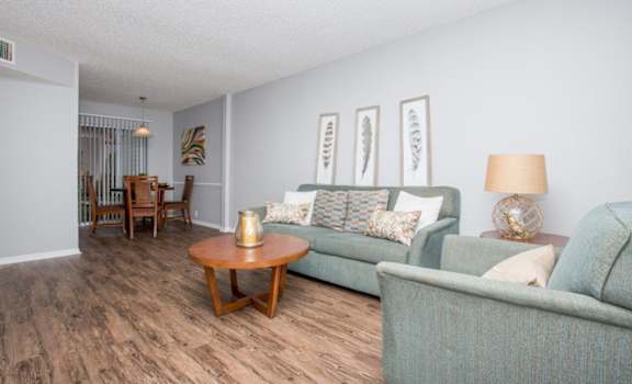a living room and dining room with couches and a table
