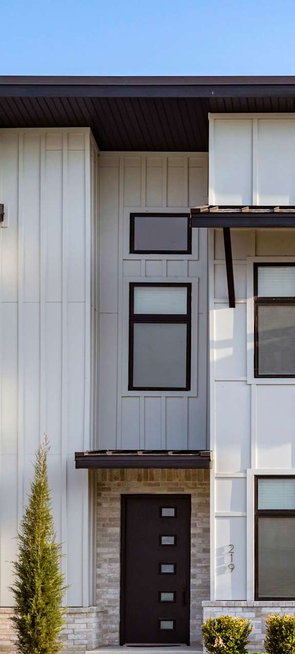 A modern house with a black door and windows.
