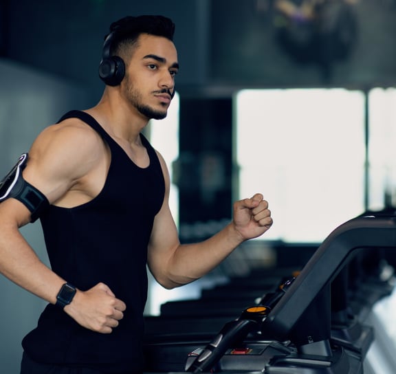 a man running on a treadmill with headphones on