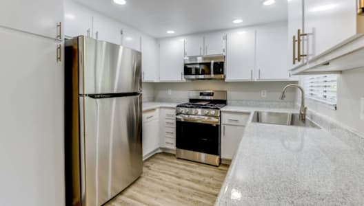 a kitchen with white cabinetry and white quartz countertops