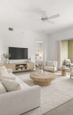 A living room with a white couch and a flat screen TV.