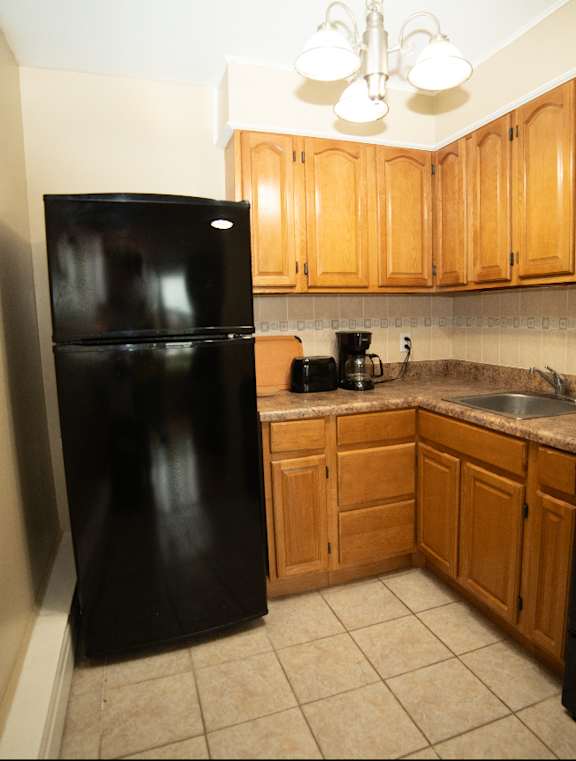 A kitchen with black appliances and wooden cabinets.