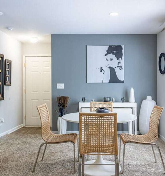A dining room with a white table and chairs.