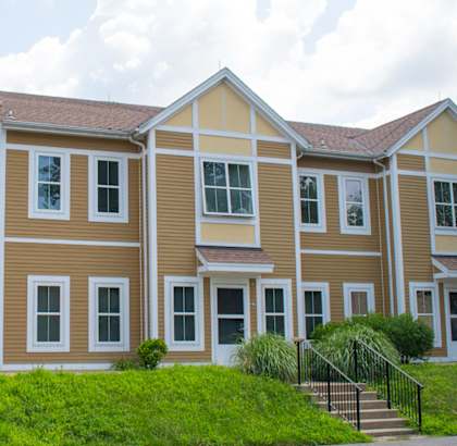a large apartment building with a grassy area in front of it
