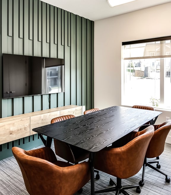a conference room with a black table and brown chairs