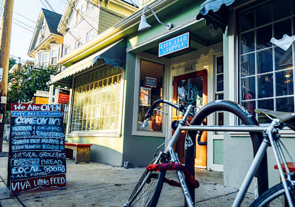 A bike is parked in front of a store with a sign that says "We are open".